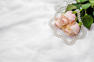 The branch of pink rose on white fabric background
