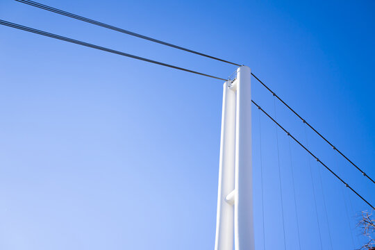 Wire ropes are connected to metal poles to create a secure perimeter in the sky background area