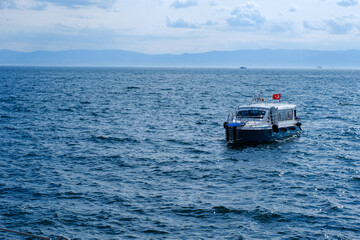 A small ship on the Bosphorus. The weather is sunny and the sea shimmers blue.