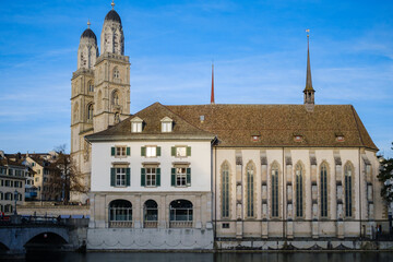 A view on Grossmünster in Zürich (Zurich) on a sunny day. In front of the Grossmünster is a nice building with shiny windows.