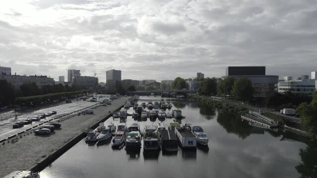 The river Erdre crossing the city on Nantes in Western France with boats and bridge, Aerial flyover shot