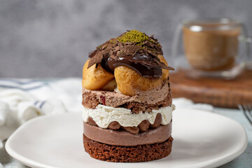 Layered profiteroles cake. Whipped cream, chocolate, and pistachio cake. Close up.