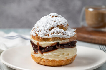 Cake with cream and liquid chocolate filling. Powdered Sugar Cake. Close up.