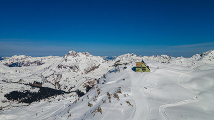 Fototapeta na wymiar Alpine ski slope mountain winter panorama with ski lift,skiers and snow covered forest.