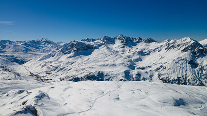 Fototapeta na wymiar Alpine ski slope mountain winter panorama with ski lift,skiers and snow covered forest.