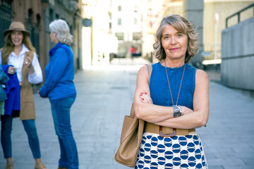 middle-aged woman posing for the camera with her group of friends behind her