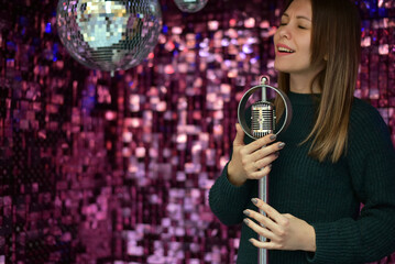 A young girl sings a song into a microphone