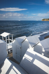 Fototapeta na wymiar White empty beach huts on Procida island, Italy.