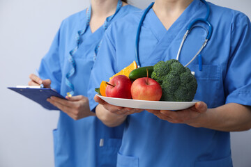 Nurses with clipboard and healthy food - healthy nutrition