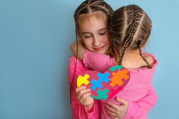 Girl hugs autistic sister tightly as sign of support and comforts. Child made card and gave it to...