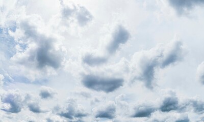 Durchscheinende graue Wolkendecke mit kleinen Cumuluswolken
