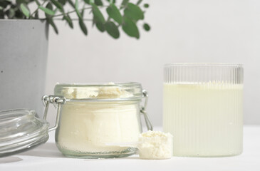 scoop of fish collagen. collagen peptides in glass jar. powder for mixing drink. Healthcare supplement concept. collagen for skin and joints and water glass.