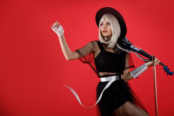 Violinist woman in the stage costume on the red background.