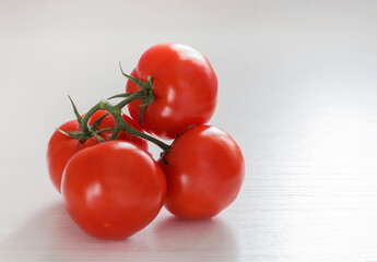 Tomatoes on a branch lying on a bright kitchen table