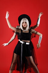 Violinist women duet in the stage costumes on the red background.