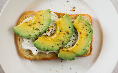A kind of healthy toast with cream cheese and avocado on toast on a plate