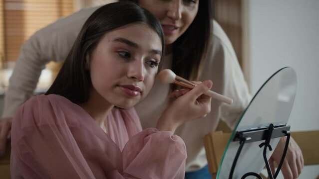 Caucasian woman teaching daughter how to do make up for a prom. Shot with RED helium camera in 8K.    