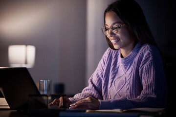 Woman, happy or laptop typing in night studying, education or homework research in living room on...
