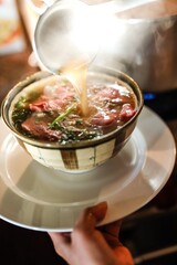 Pho Perfection: Capturing the Pouring of Broth into a Bowl of Vietnamese Pho