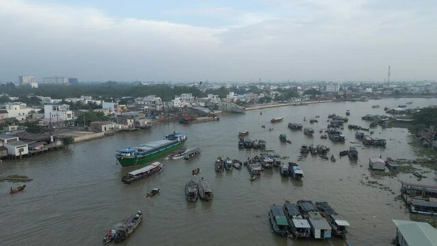 Ship freighter passes crowd of river boats at Cai Rang Floating Market