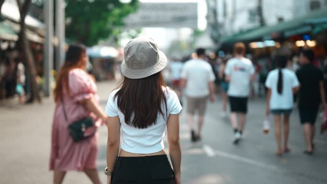 woman traveler visiting in Bangkok, Tourist with hat sightseeing in Chatuchak Weekend Market, landmark and popular attractions in Bangkok, Thailand. Travel in Southeast Asia concept