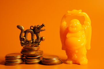 Dragon figurine and Buddha on a bright colored background. Religious and spiritual symbol.