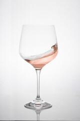 GLASS OF ROSE WINE IN MOTION