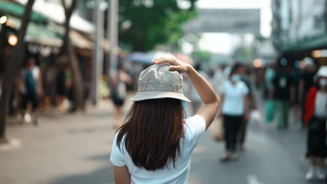 woman traveler visiting in Bangkok, Tourist with hat sightseeing in Chatuchak Weekend Market, landmark and popular attractions in Bangkok, Thailand. Travel in Southeast Asia concept