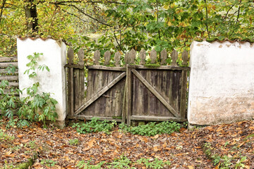 Old wooden wicket with white brick wall in fall