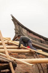 A worker repairs Chinese old historical buildings