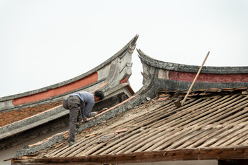 Fototapeta na wymiar A worker repairs Chinese old historical buildings