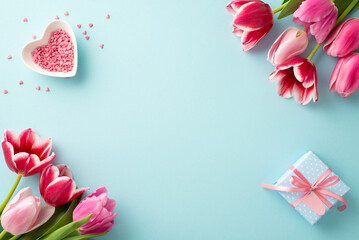 Mother's Day decorations concept. Top view photo of pink tulips small giftbox and heart shaped saucer with sprinkles on isolated pastel blue background with copyspace