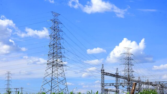 cloud timelipse bright blue sky background. white cloud hyperlipse. movement of clouds over the power substation tower. power supply technology with very high voltage lines. natural scenery in summer.