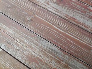 The wall of the building is made of old boards. The paint peels off, there are cracks and scuffs.