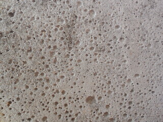 Textured surface of an old concrete block in the wall.