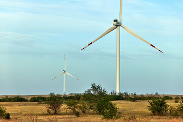 Fototapeta premium Silhouette of wind turbines at sunset. The concept of alternative energy.