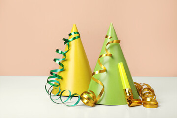 Colorful party hats, streamers and blower on white table. Birthday celebration