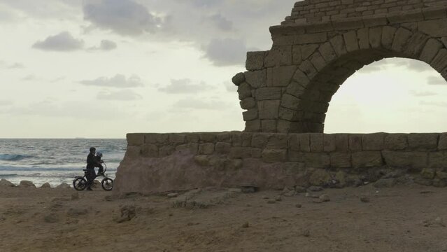 Caesarea Israel beach with ancient Roman ruins family walks along the water on vacation in Jewish land