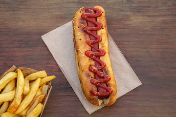 Fresh tasty hot dog and french fries on wooden table, flat lay