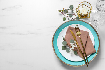 Stylish table setting with cutlery, flower and eucalyptus leaves, flat lay. Space for text