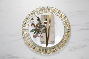 Fototapeta na wymiar Stylish setting with cutlery and eucalyptus leaves on white marble table, flat lay