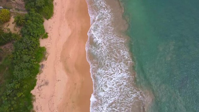 Aerial view from above on a beautiful sandy sea shore. Ocean coast. Calm beautiful video on the background for tourism, design and advertising