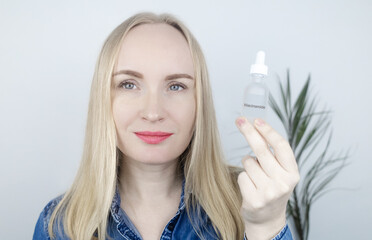 Niacinamide. Girl applies vitamin b3 to her face. Laboratory research. Skincare. Dermatological serum. Emulsion for narrowing of pores, normalization of sebum production and lightening of pigmentation