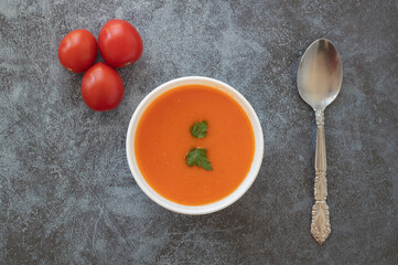 Natural tomato soup in white bowl , top view .