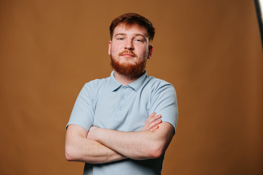 A fiery Redhead Teen Guy poses in the studio, his intense gaze fixed on the camera.