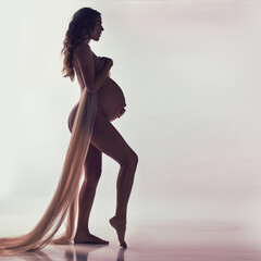 Woman, pregnant and fabric with silhouette in studio with hands, touch and healthy by white...
