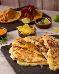 quesadilla con bistec y complementos sobre mesa de madera, tradicional comida mexicana
