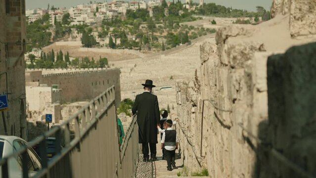 Religious Orthodox Haredi Jew walks in the holy city of Jerusalem with family of Israel