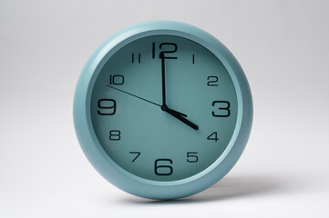  light blue clock hanging on white wall