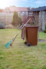 Grass dumpster, rake and manual reclamator to take care of your lawn in spring. Early spring work in the garden after winter.